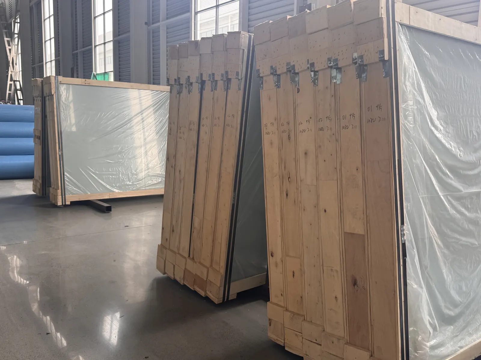 Wooden crates protecting large padel court glass and components before export